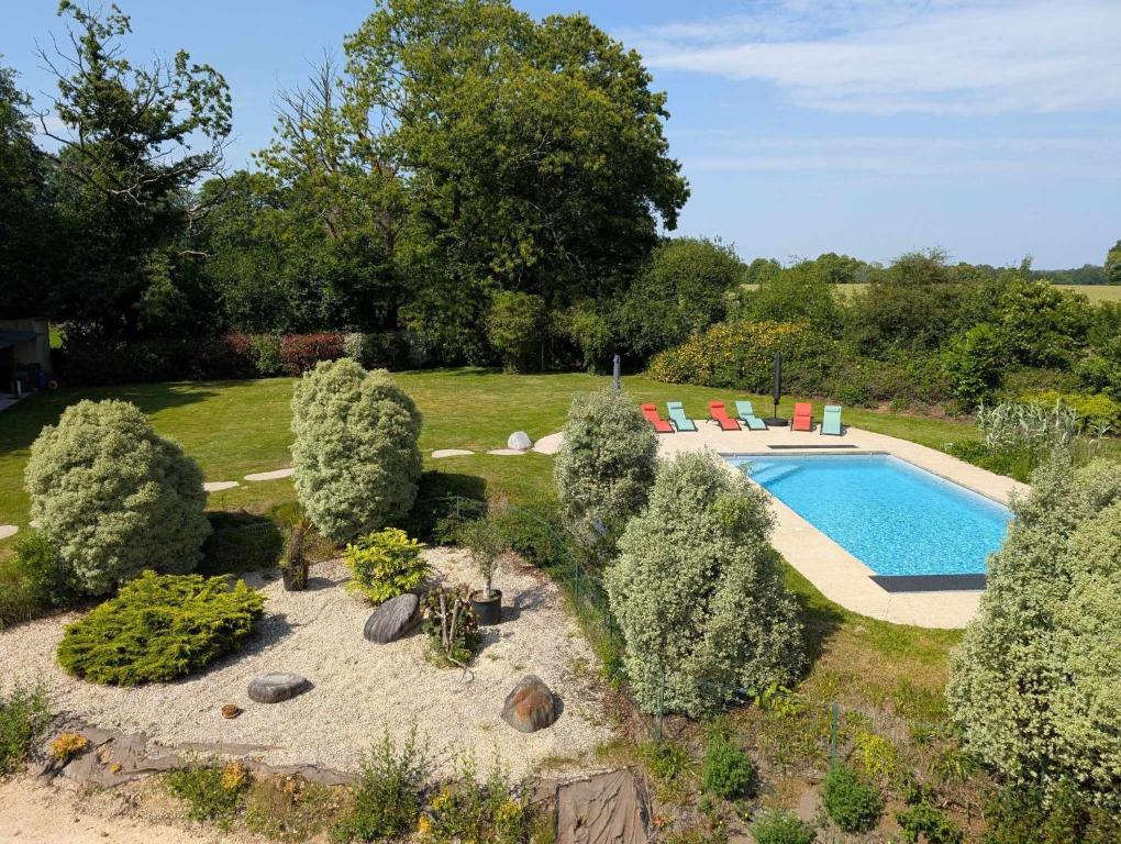 a swimming pool in a garden with trees and a yard at Domaine de Kerhallec in Treffléan