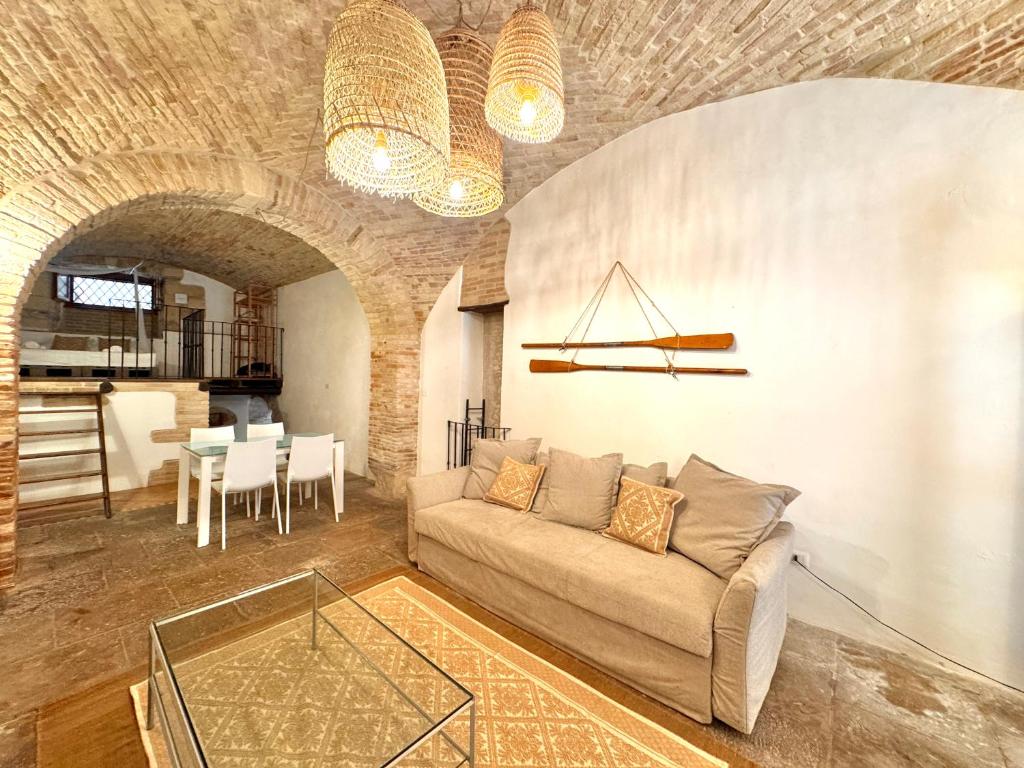 a living room with a couch and a table at Kalma Arched Loft - Unique Brick Vault in City Heart in Cagliari