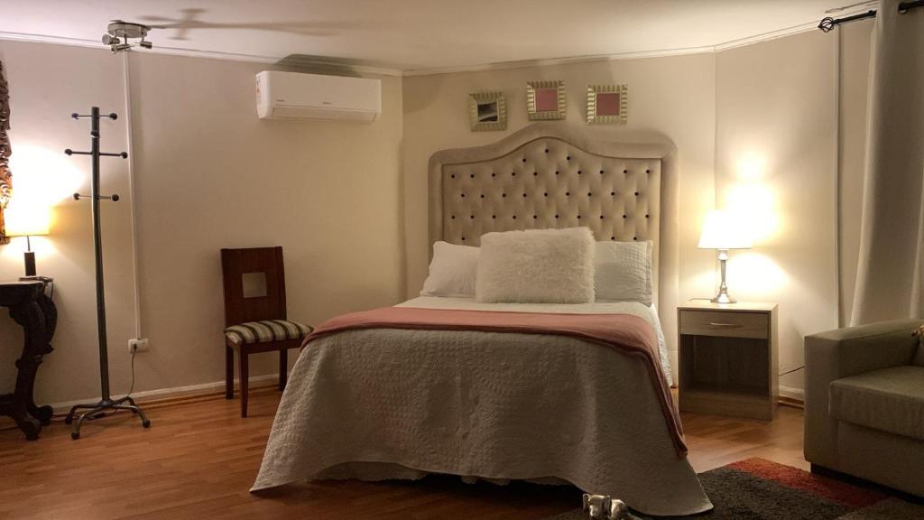 a bedroom with a bed and a cross on the wall at Habitación Deluxe Acogedora Elsita in Santiago