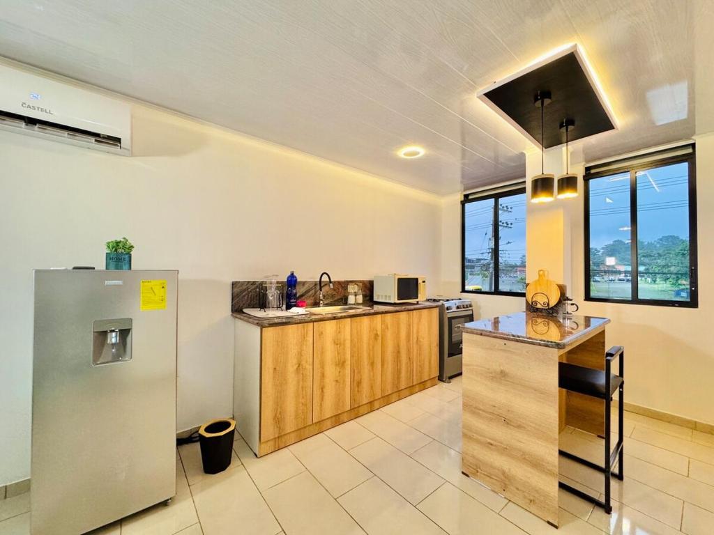 a kitchen with a refrigerator and a counter top at Departamento de lujo y acogedor in Santo Domingo de los Colorados