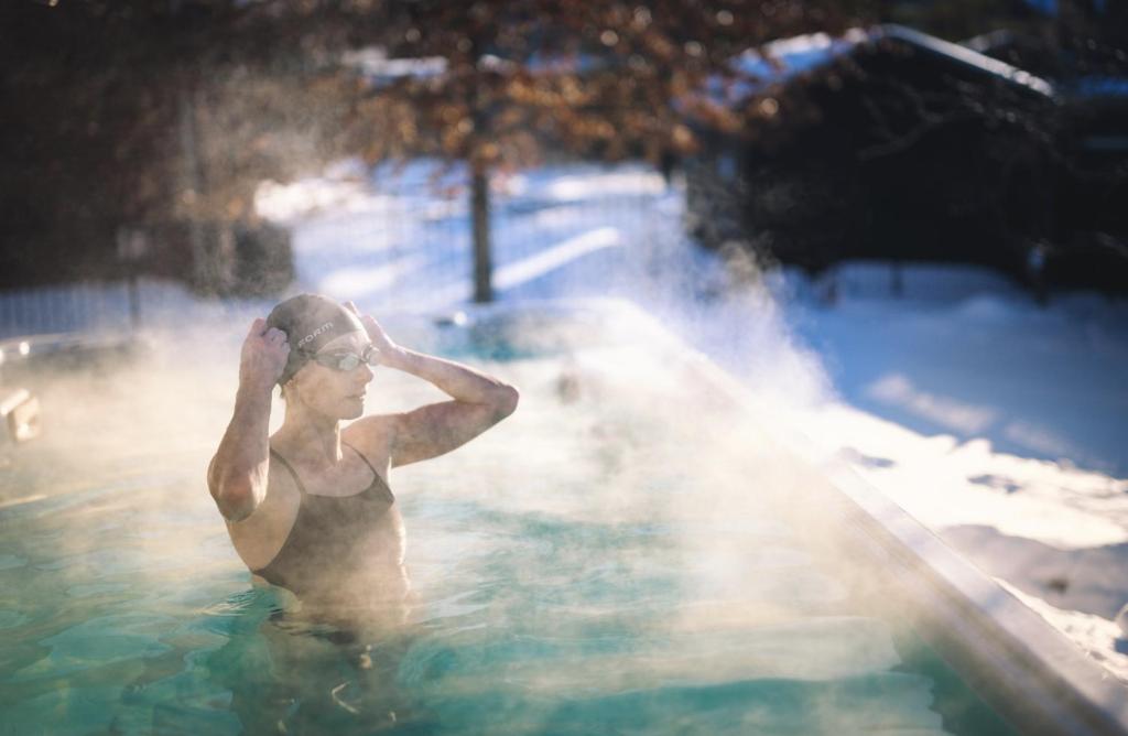 a man standing in a pool with a hot tub at PARADISE SHARED SHORT STAy in Bowmanville