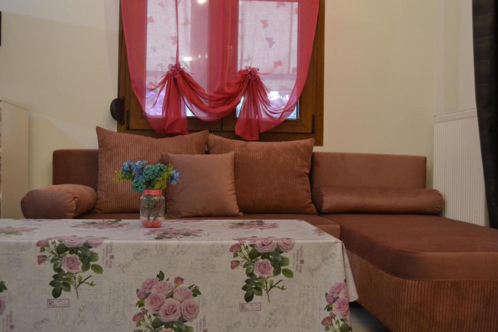 a living room with a couch and a table with flowers on it at Oikia Samiotaki Emmanouil in Sarti