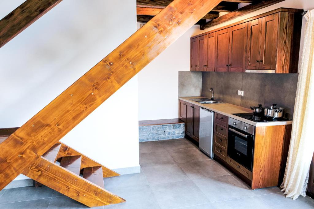 a kitchen with wooden cabinets and a wooden staircase at To Mpalkoni in Chorefto