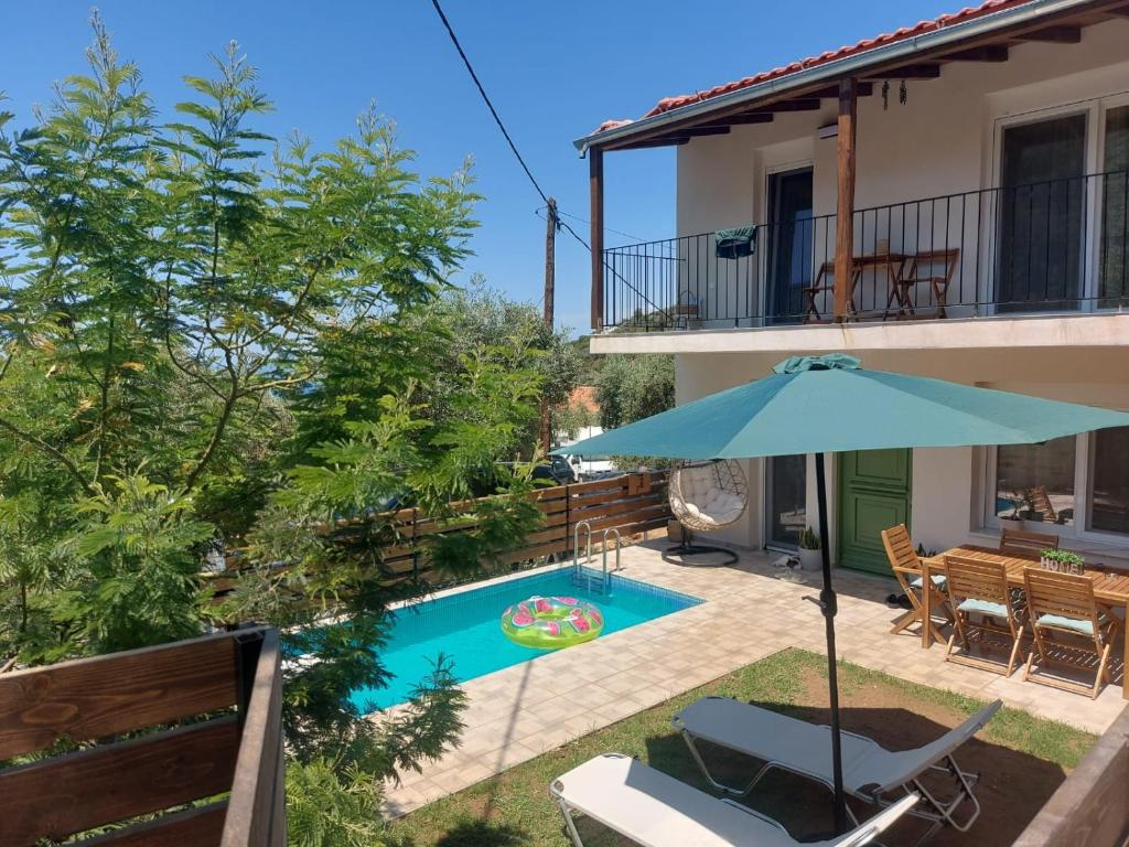 a patio with an umbrella and a swimming pool at Abigails Pool House in Kallirákhi