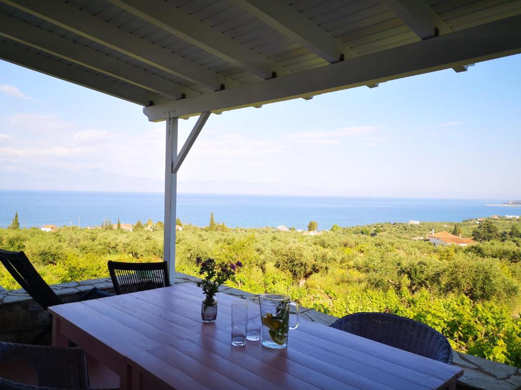 a table on a porch with a view of the ocean at The Iconpainter Zaga Villa in Kómboi