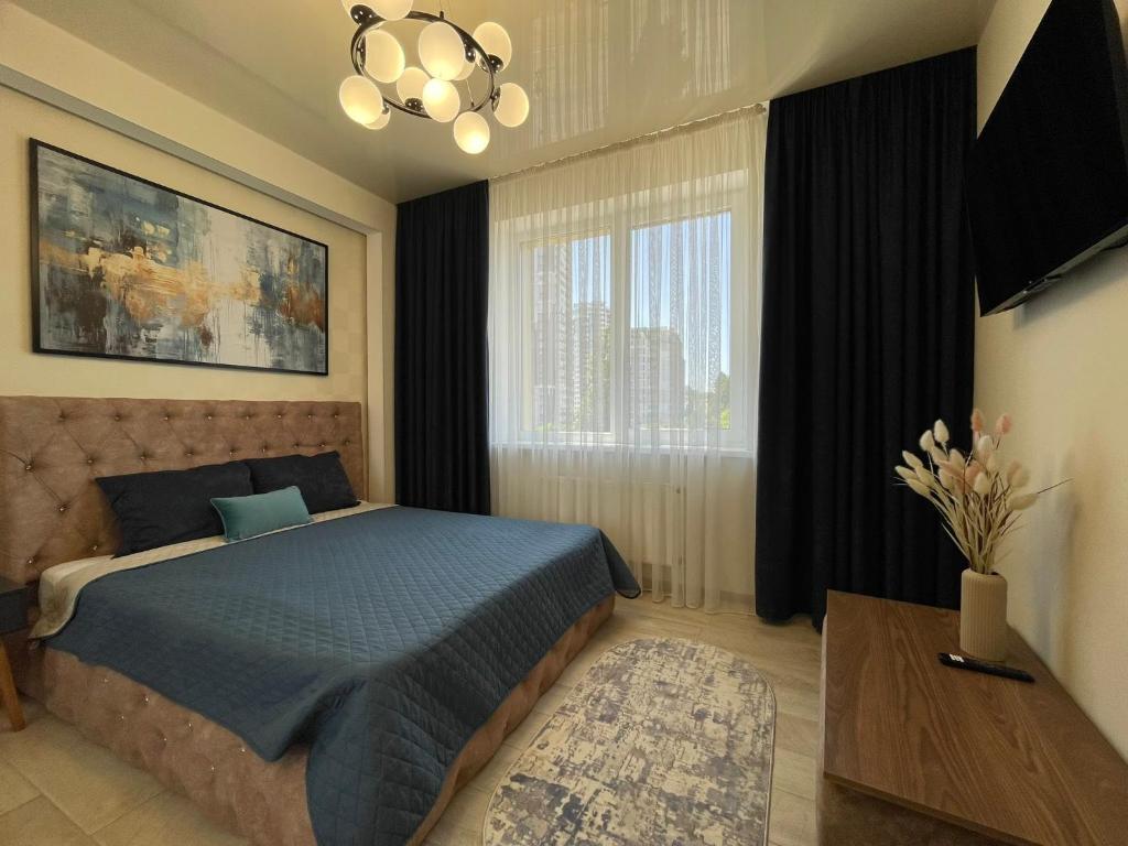 ein Schlafzimmer mit einem blauen Bett und einem Fenster in der Unterkunft Двухкомнатная квартира в Аркадии с двумя кроватями две отдельные спальни in Odessa