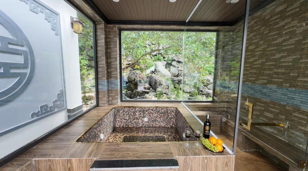 a bathroom with a bath tub with a window at Tam Coc Ecolodge in Vũ Lâm