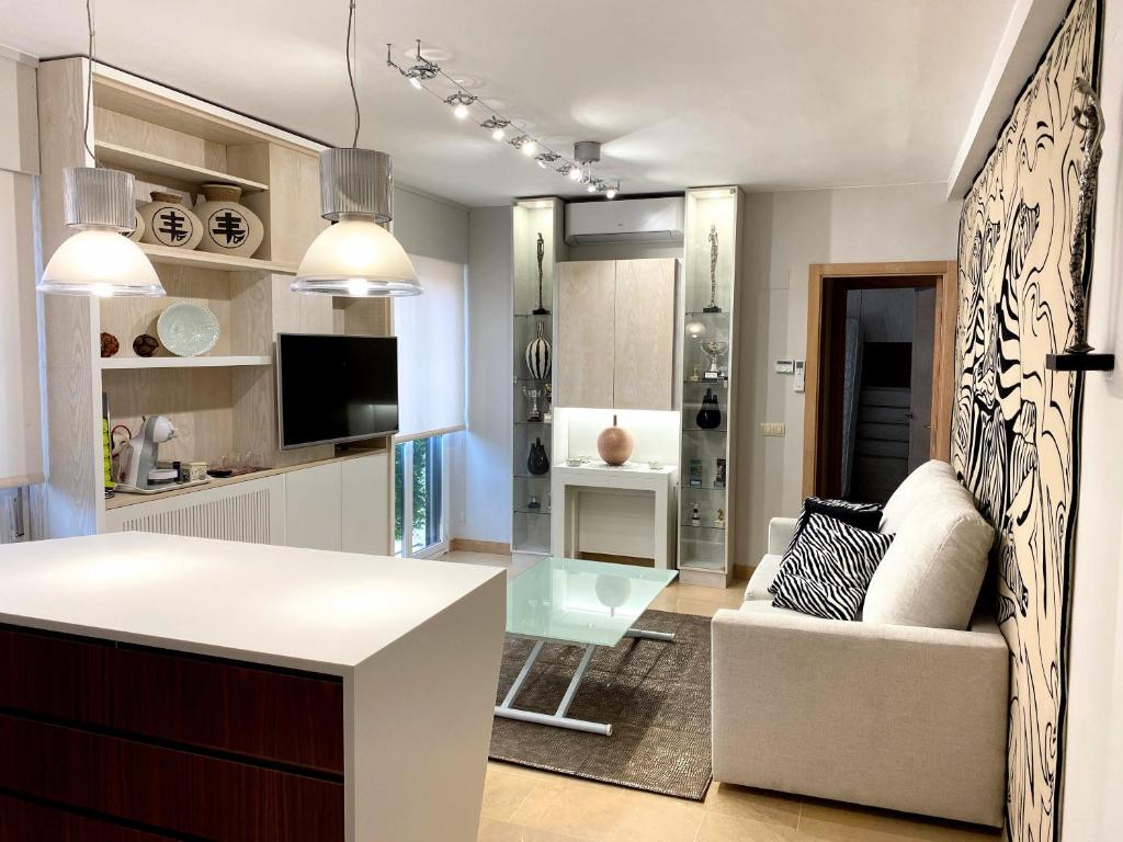 Una cocina y una sala de estar con un sofá y una mesa. en Acogedor apartamento con acabados primera calidad, en Zaragoza
