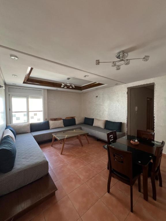 a living room with a couch and a table at Apartment with pool near beach in Fnidek