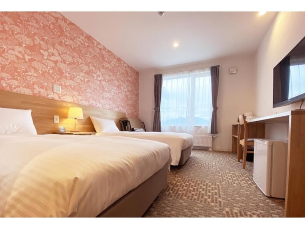 a hotel room with two beds and a window at Hotel Hanafuji Inn - Vacation STAY 60981v in Nakafurano