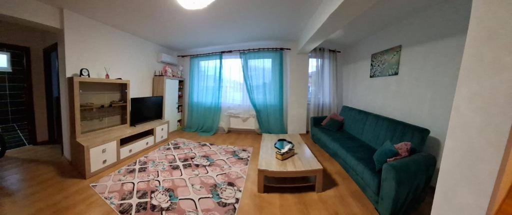 a living room with a green couch and a table at Apartament Tiana in Mamaia Nord