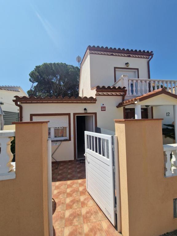 a house with a white gate in front of it at Apartamento Riells in L'Escala