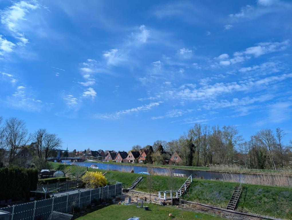 a view of a park with a river and houses at Emden - Ferienwohnung mit Kanal-Blick in Emden