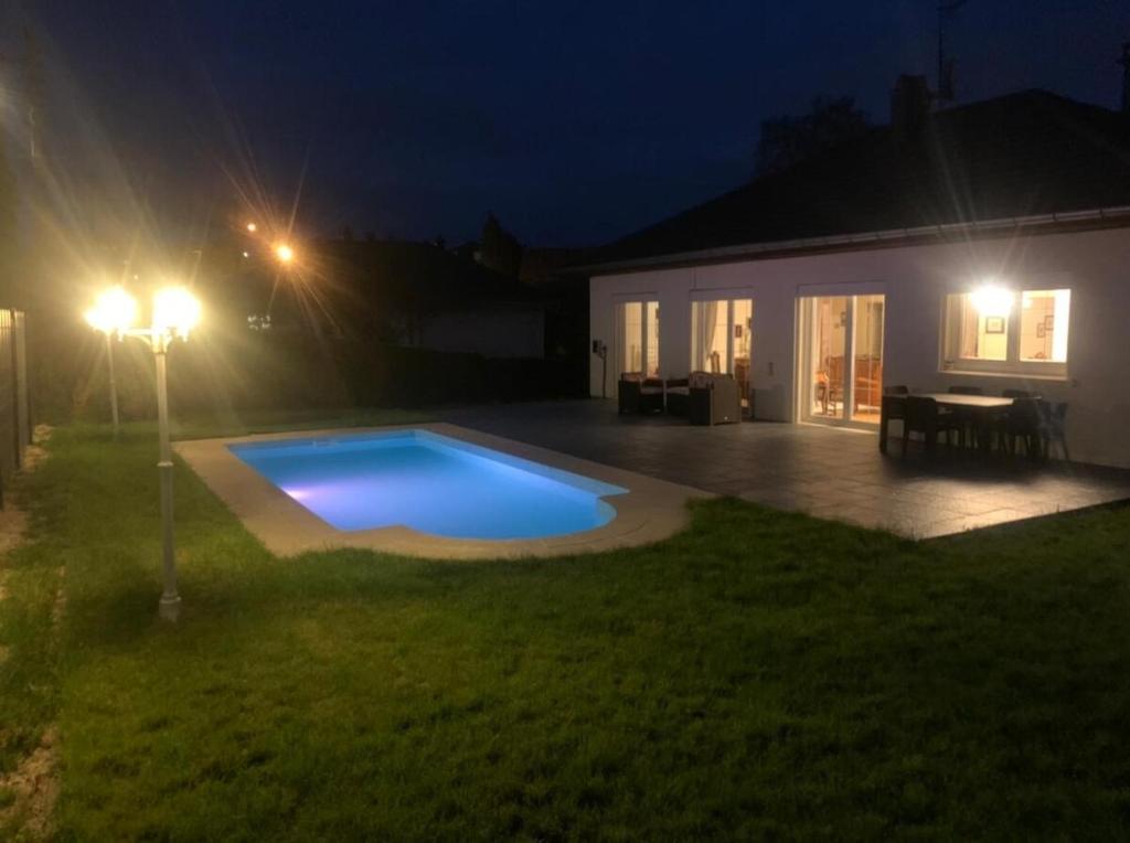 モンベリアルにあるMaison jardin barbecue parkingの夜間の庭のスイミングプール