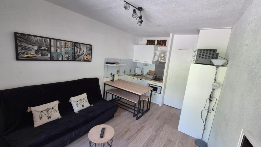 un salon avec un canapé et une petite cuisine dans l'établissement AU VAL BENOÎT chez sylvain, à Allos