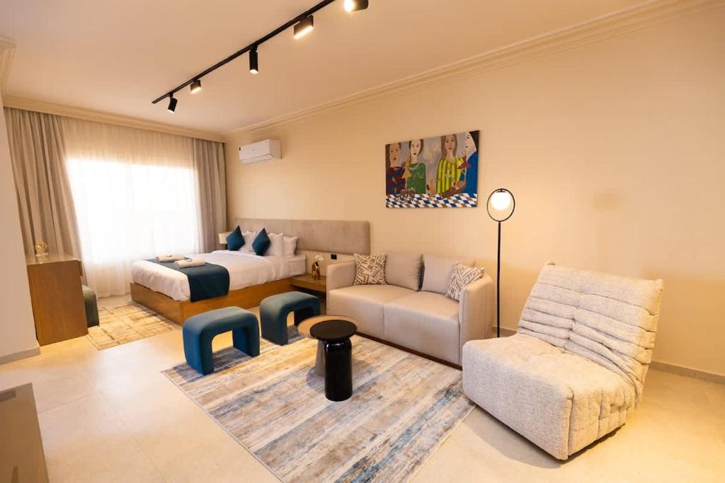 una sala de estar con un sofá y una cama en Luxury Modern Studio Ensuite By Beithady, en New cairo