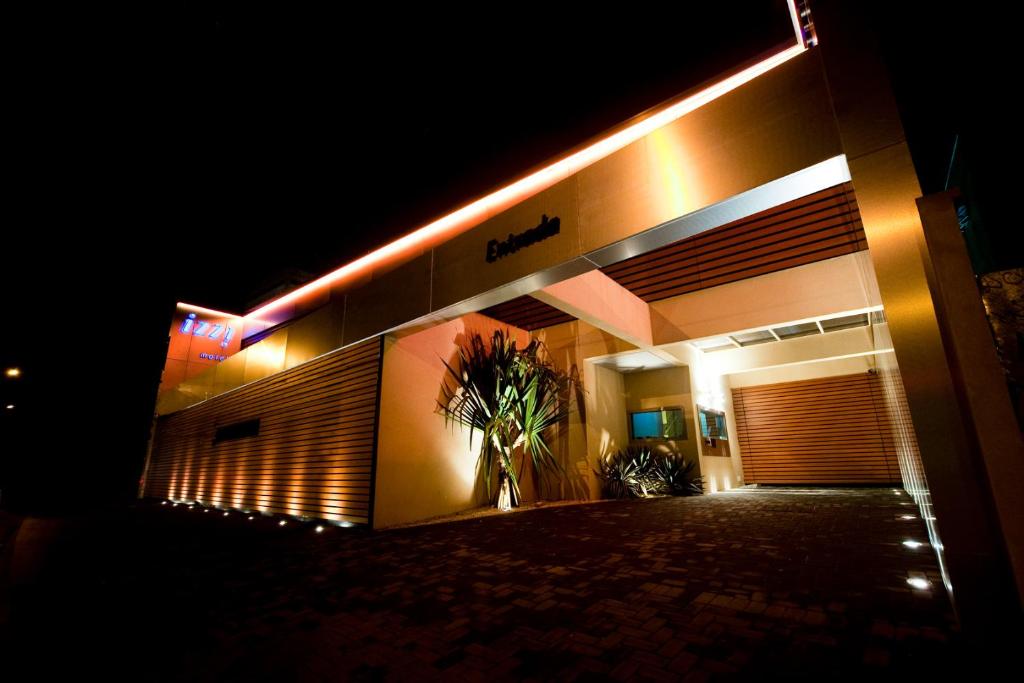 a building with a plant in front of it at night at Izzi Motel 2 in Sao Paulo