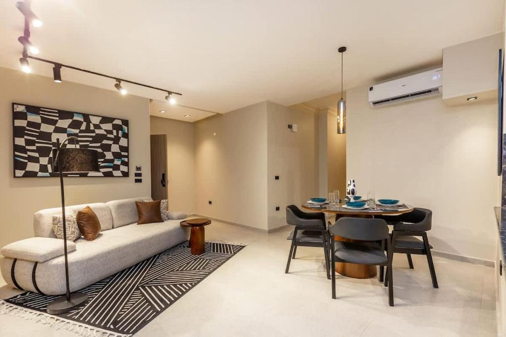una sala de estar con un sofá y una mesa en Luxury 2 BR - 1 Ensuite - POOL - By Beithady - BH-26-402, en New cairo