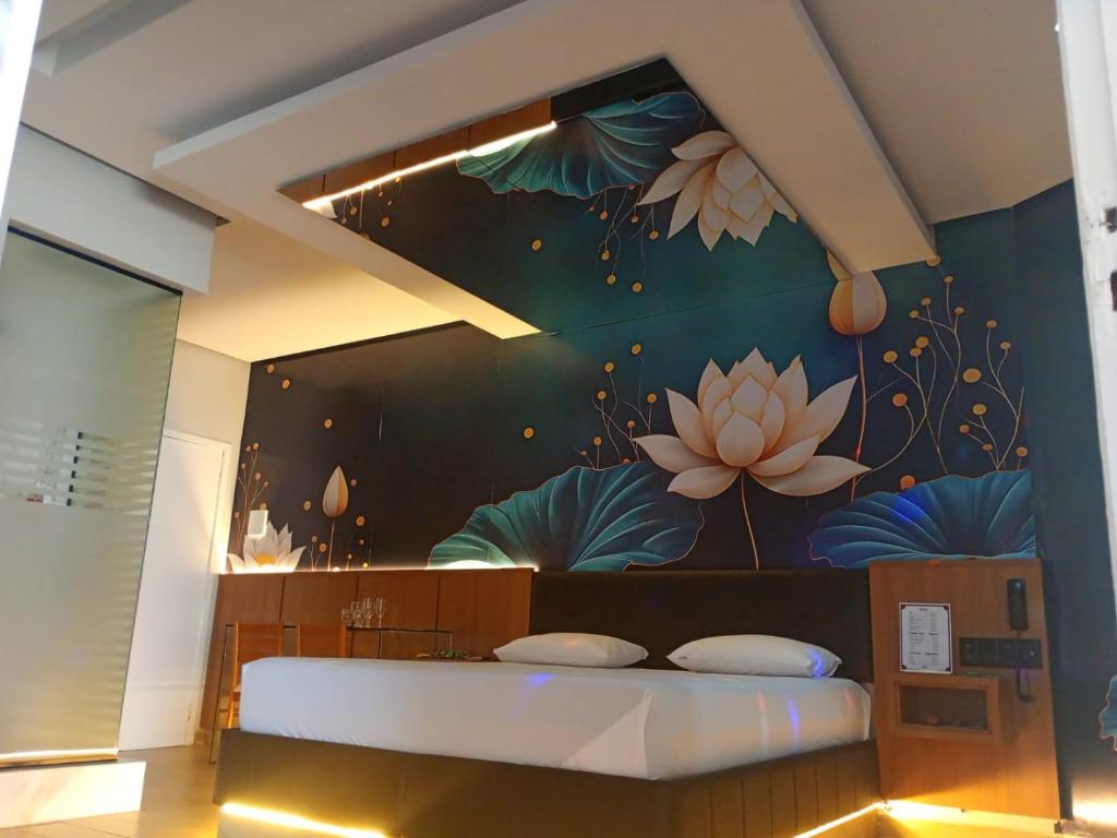 a bedroom with a bed with a flower mural on the wall at STILLUS - Hotel e Motel in Imperatriz