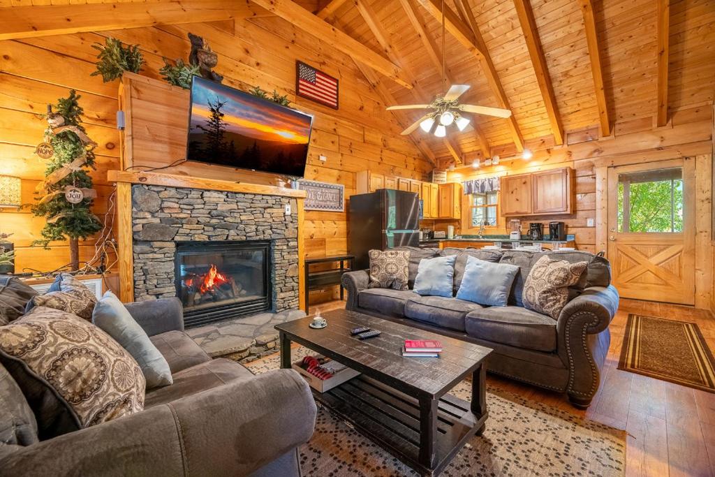 a living room with couches and a fireplace at Anglers Bend By Avada Properties in Pigeon Forge