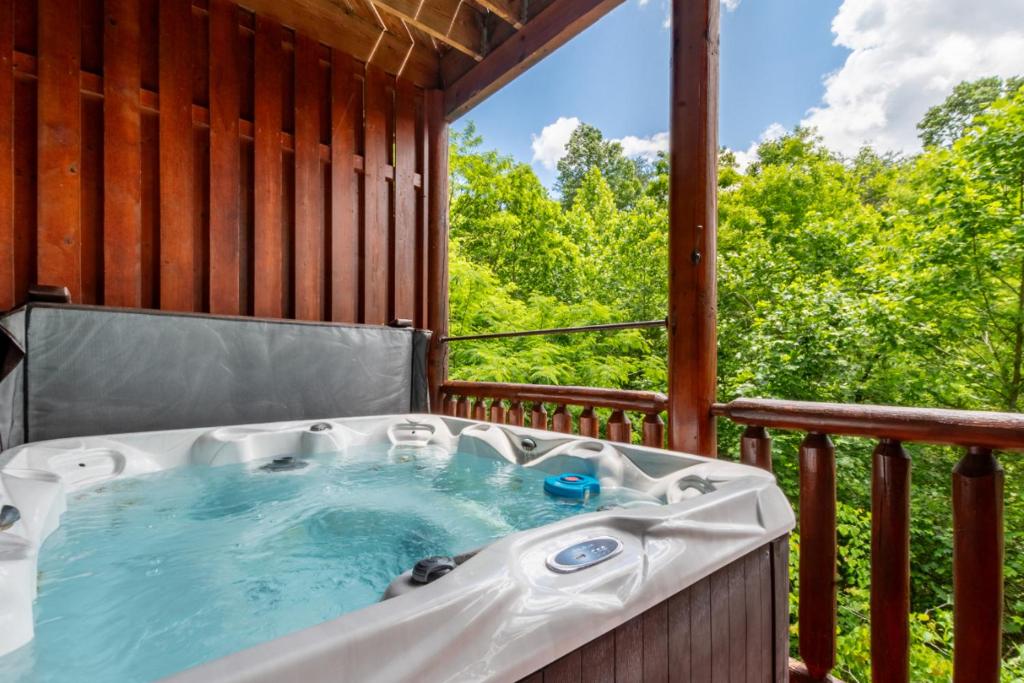 a hot tub on the deck of a cabin at Bear Essentials Lodge By Avada Properties in Sevierville