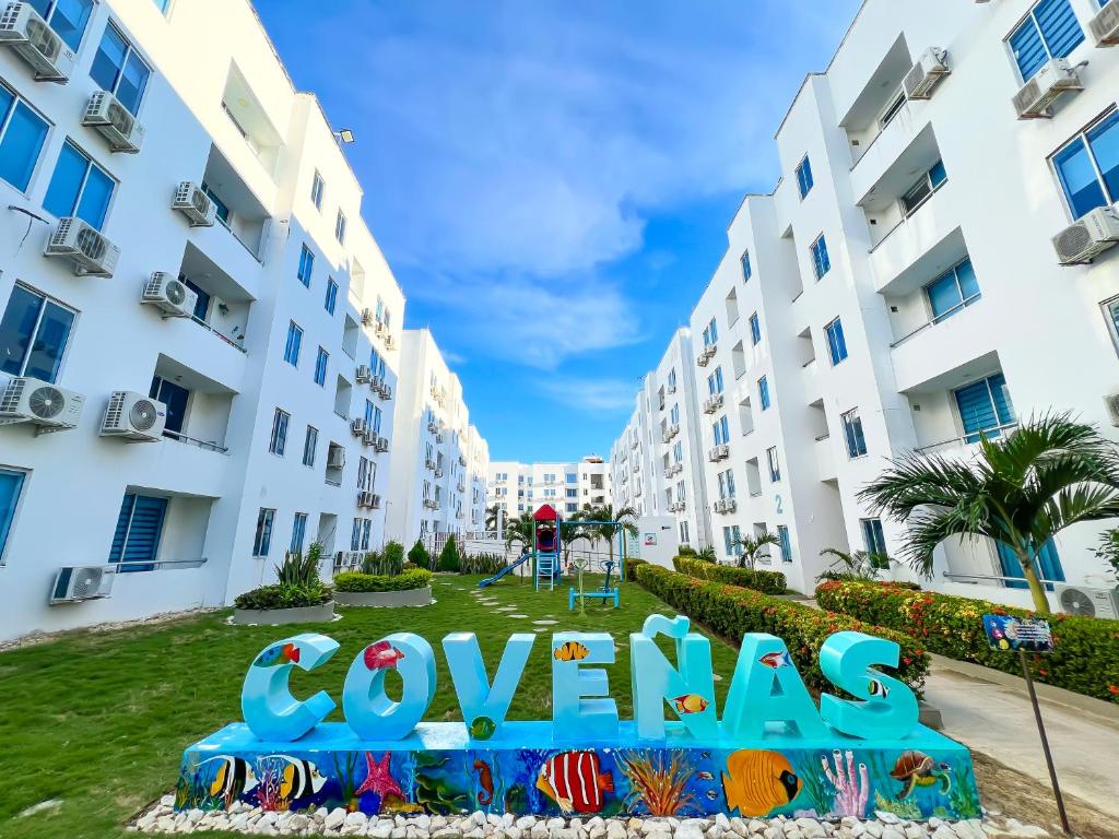 a sign in front of two apartment buildings at apartamento con alma 888 in Coveñitas