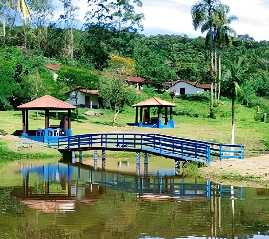 a blue bridge over a body of water at Casas de Campo com Piscina, Pesca - Mata Atlântica in Juquitiba