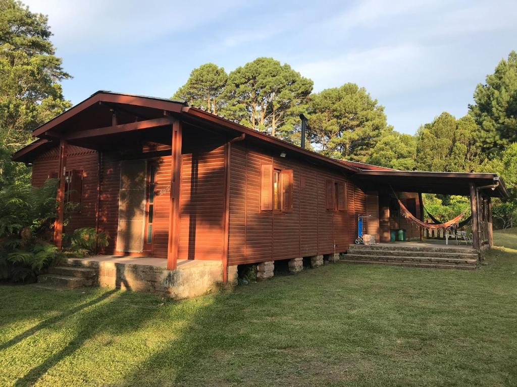 a log cabin with a porch on a lawn at Encantos de São Chico - Aconchego Serrano in São Francisco de Paula