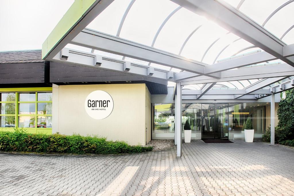 an external view of a building with a glass roof at Garner Hotel Erlangen Süd by IHG in Erlangen