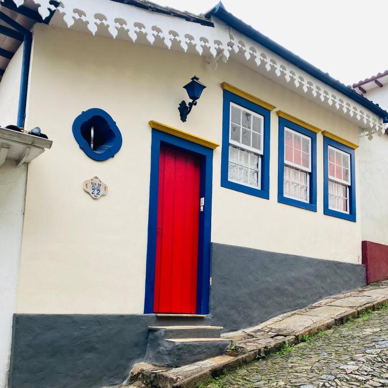 a house with a red door and blue windows at Cantinho Pilar in Ouro Preto