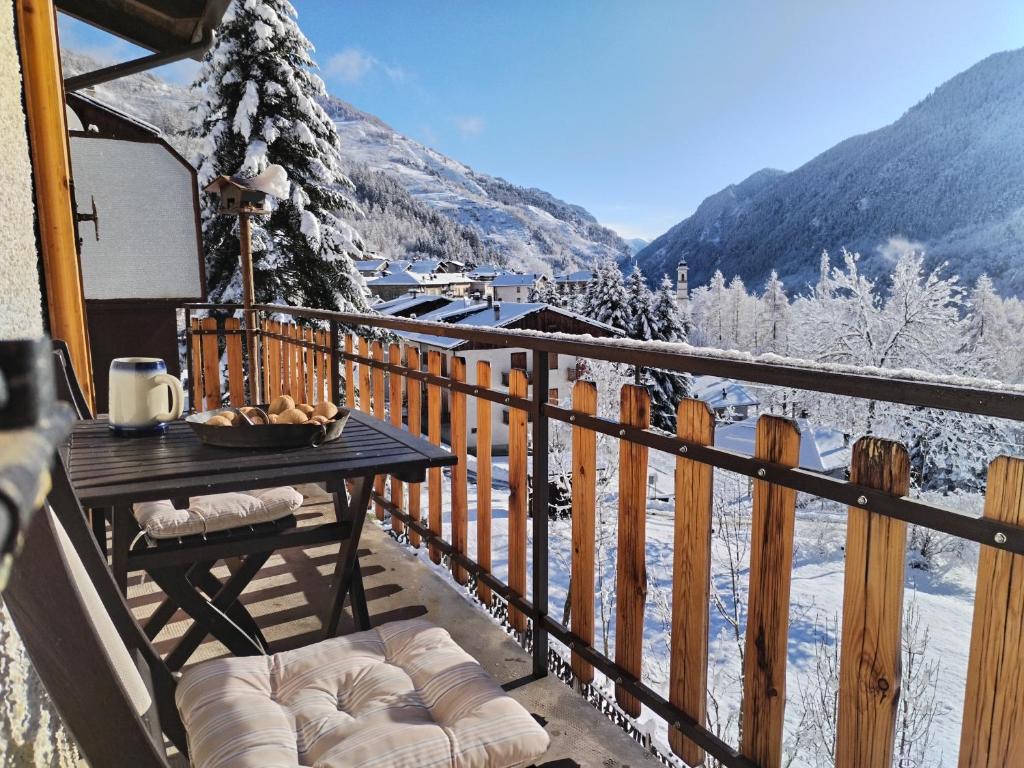 een tafel op een balkon met een met sneeuw bedekte berg bij Castori 1 in Prazzo