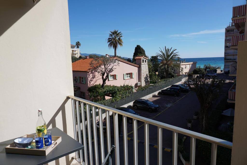- un balcon avec une table et un verre de vin dans l'établissement Appartement Vue mer avec Piscine, à Roquebrune-Cap-Martin
