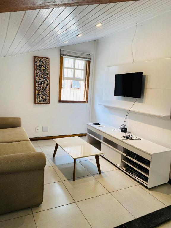 ein Wohnzimmer mit Sofa und Fernseher in der Unterkunft Cantinho Familia in Ouro Preto