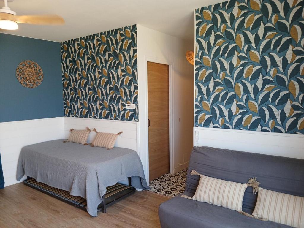 a room with two beds and a wall mural at Front de mer - Le Barcarès in Le Barcarès
