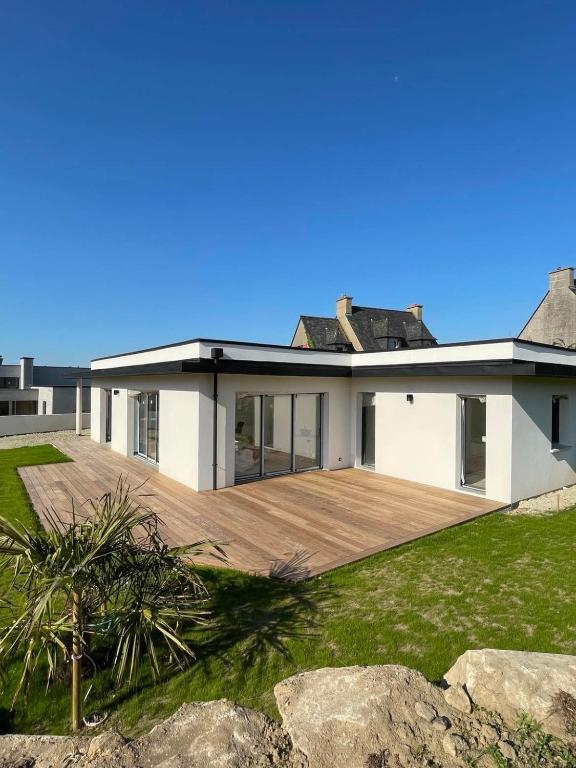a house with a large deck in front of it at Ty Rosc'OFF, Plain-pied de charme, tout récent, à proximité immédiate du centre de Roscoff in Roscoff