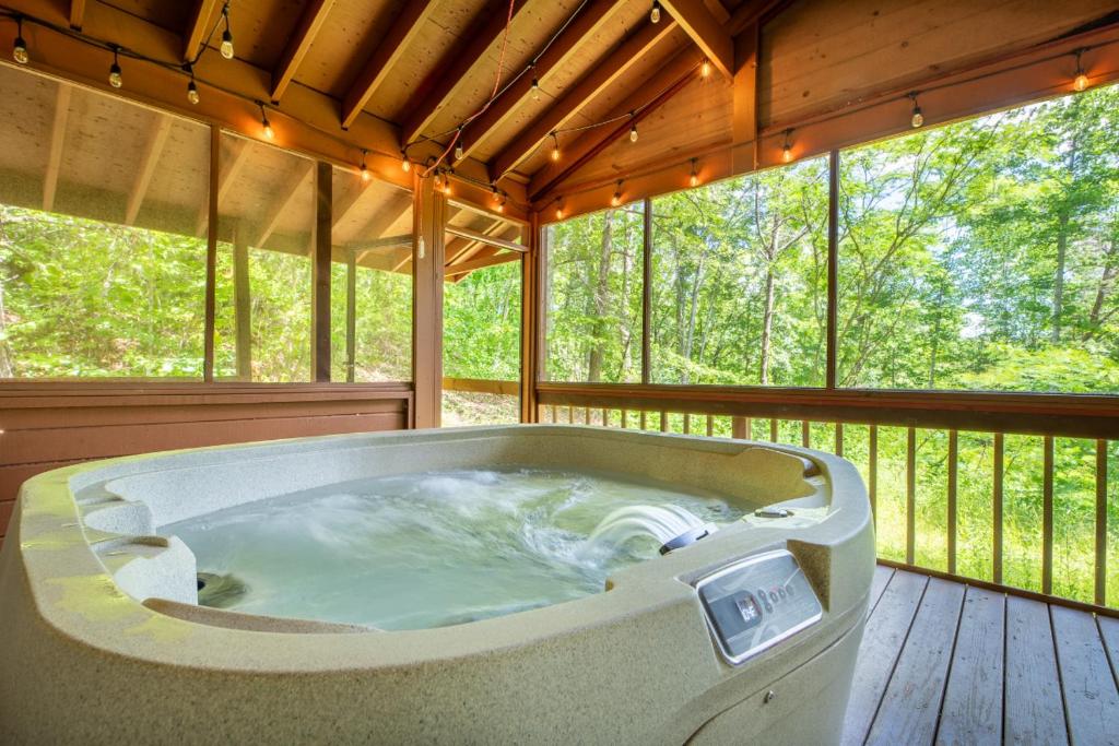 een grote hot tub op een afgeschermde veranda bij Haus Edelweiss By Avada Properties in Sevierville