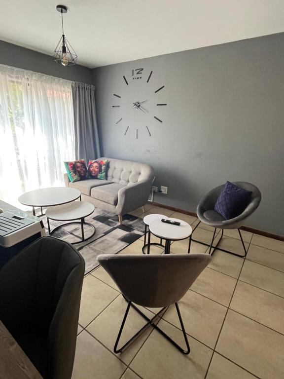 een woonkamer met een bank en een klok aan de muur bij 2 Spacious bedroom apartment in Lephalale