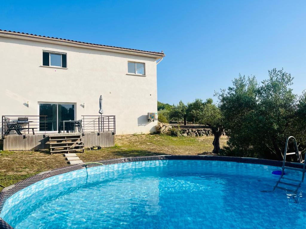 a villa with a swimming pool in front of a house at Villa Bahia - bas de villa en pleine nature ! in Saint-Mitre-les-Remparts