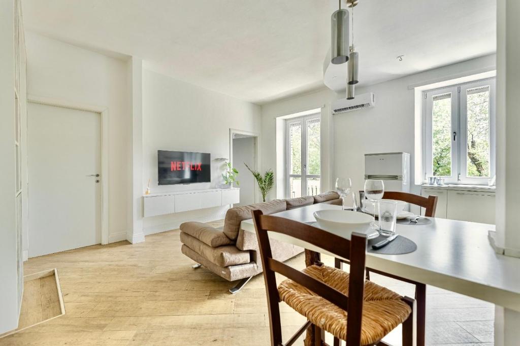 Una cocina y una sala de estar con una mesa y un sofá. en Blanc72, en Turín