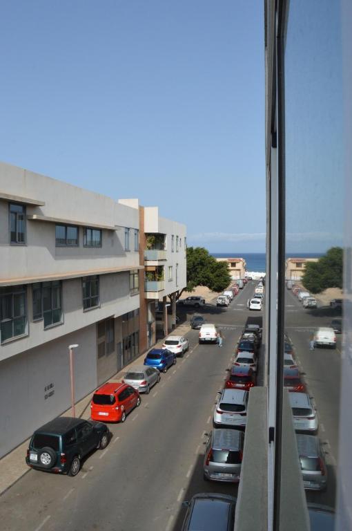 a street with cars parked in a parking lot at Casa Zenn in Puerto del Rosario