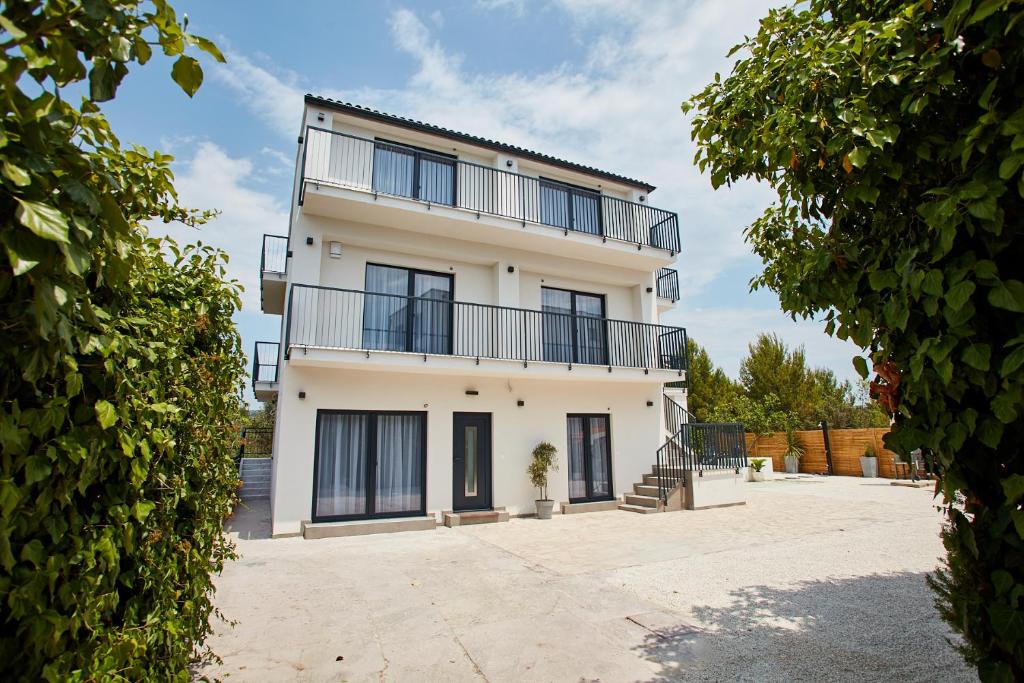 an apartment building with balconies and a courtyard at Villa Cherry in Rogoznica
