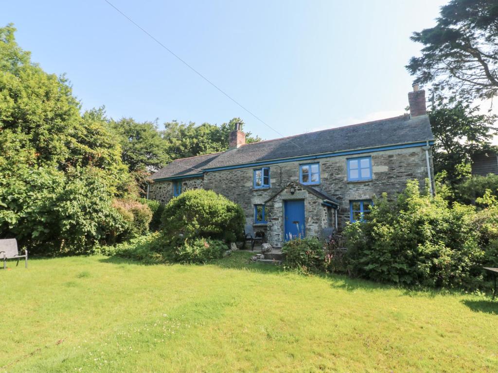 an old stone house with a blue door at Sunnyvale Cottage in Penzance