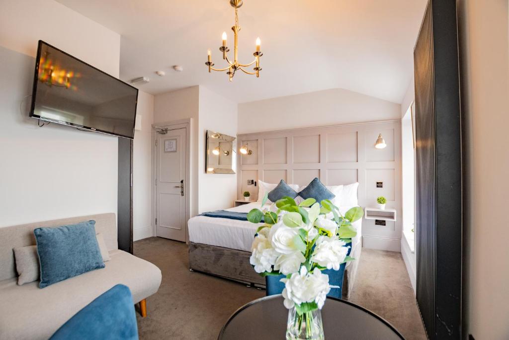 a bedroom with a bed and a table with a vase of flowers at Superb Marina Studio- Sleeps 3 in Dublin