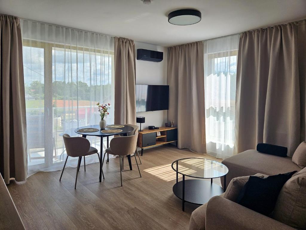 un salon avec un canapé, une table et des chaises dans l'établissement Kairos Apartments -Atos - darmowy parking, klimatyzacja, à Olsztynek