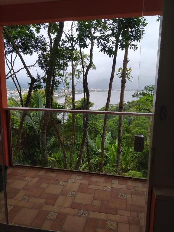 a room with a view of the ocean through a window at Chalés Ubatuba do Alto in Ubatuba