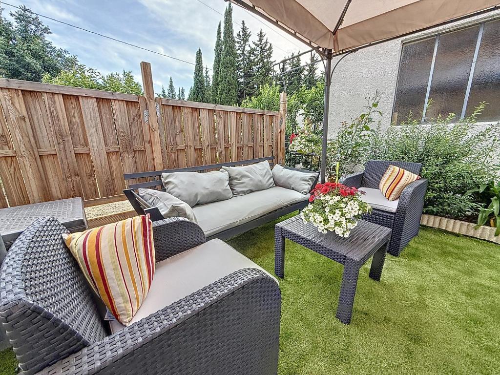 un patio avec des chaises, un canapé et une table dans l'établissement Maison avec jardin privatif à 3KM des plages, à Fréjus