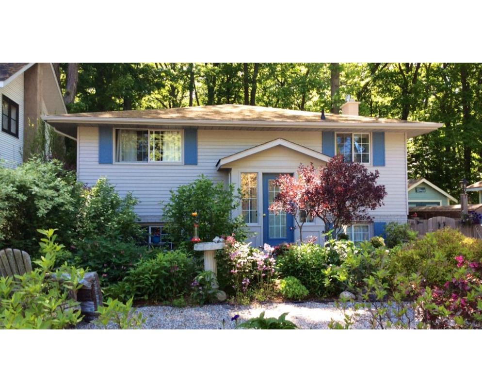 una casa azul con un jardín frente a ella en Westwood Cottage License #045-2020, en Niagara on the Lake