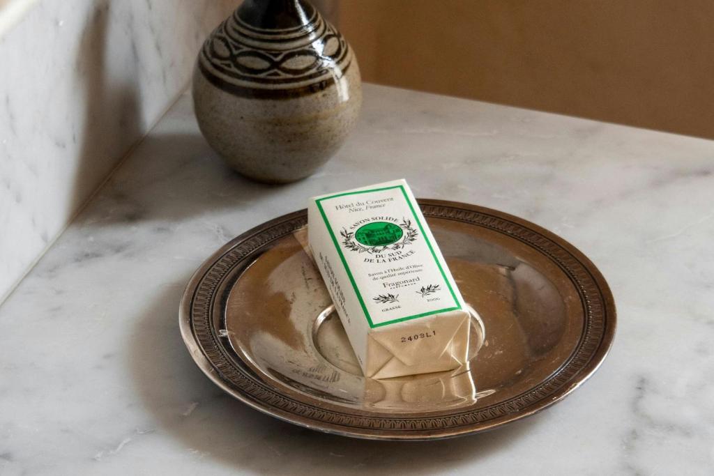 a carton of milk on a plate with a vase at Hôtel du Couvent, a Luxury Collection Hotel, Nice in Nice
