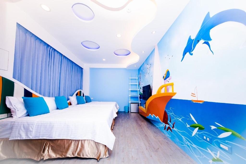 a bedroom with a bed and a dolphin mural at Zih Yue Tong Homestay II in Magong