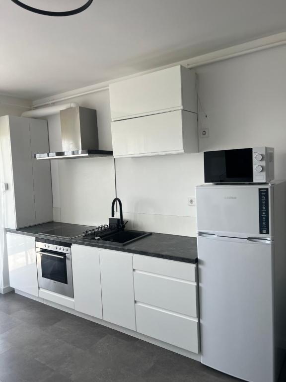 a white kitchen with white cabinets and appliances at Apartment Cluj, Baciu-Hills in Baciu